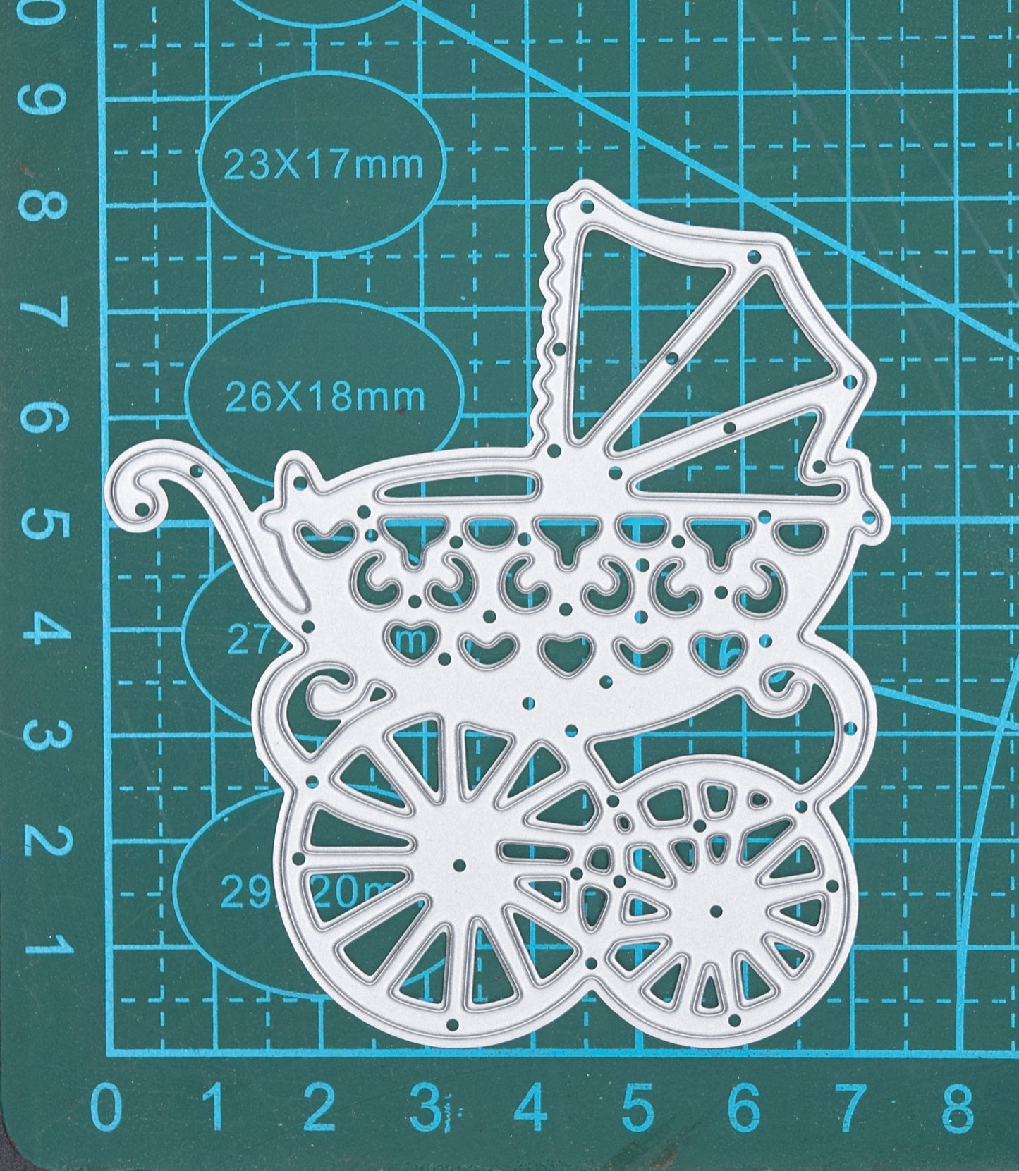 Baby pram metal cutting die on measuring mat showing approximate dimensions