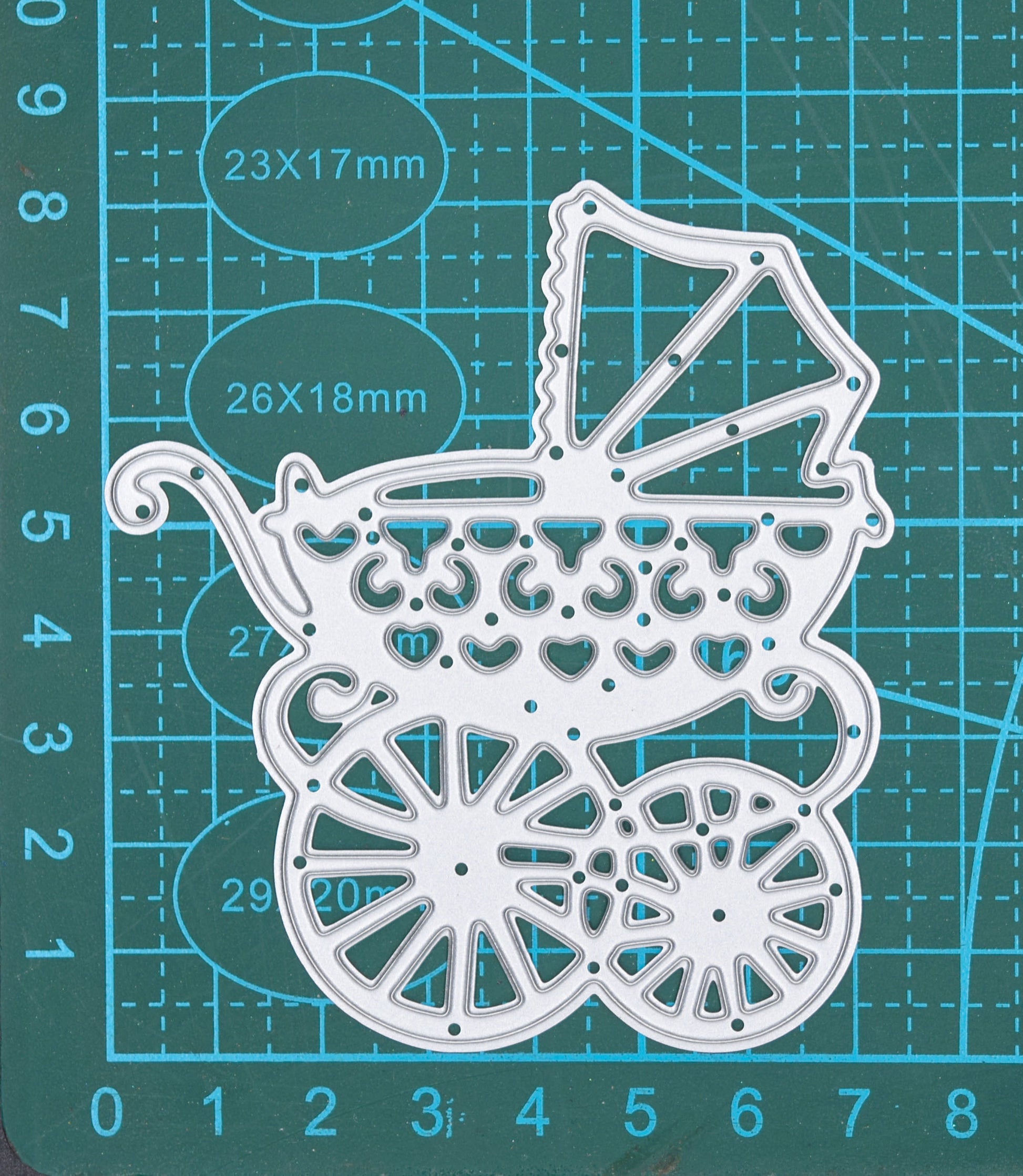 Baby pram metal cutting die on measuring mat showing approximate dimensions