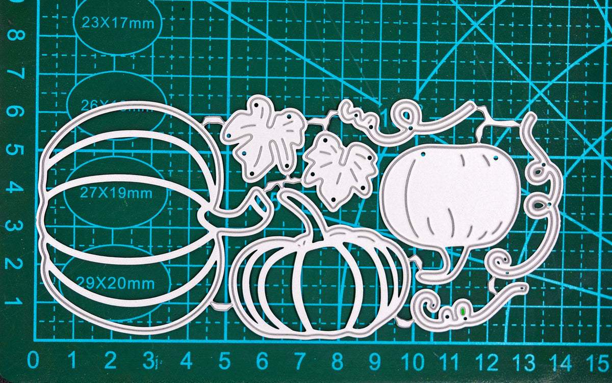 Pumpkin, leaves and curling vine metal cutting die set shown on a cutting mat for size reference.