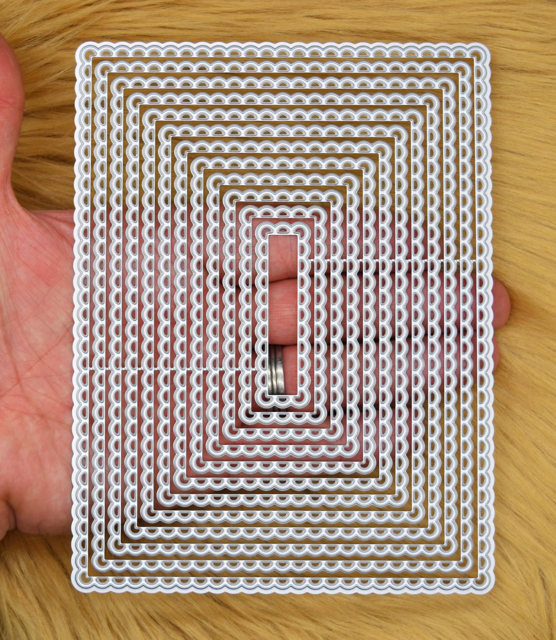 Large scalloped rectangle nesting metal cutting dies shown in hand for size reference and layering card designs