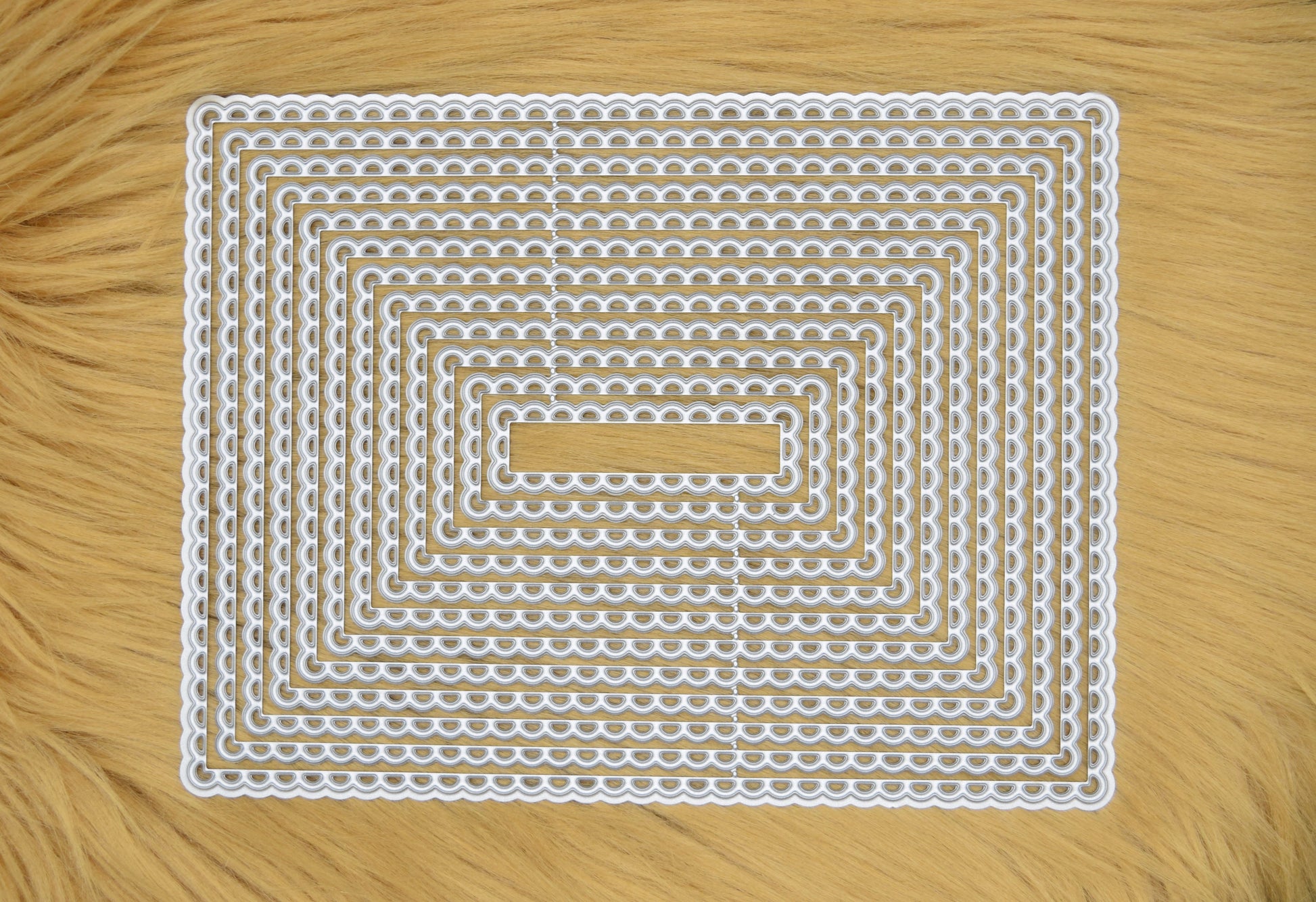 Large rectangle scalloped nesting metal cutting die set displayed on faux fur background for papercraft and card making