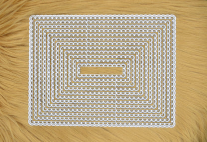 Large rectangle scalloped nesting metal cutting die set displayed on faux fur background for papercraft and card making