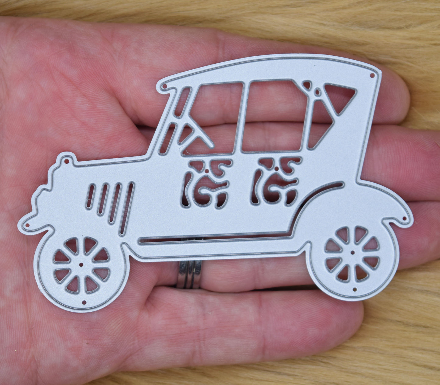 Vintage retro car cutting die shown in hand for size reference
