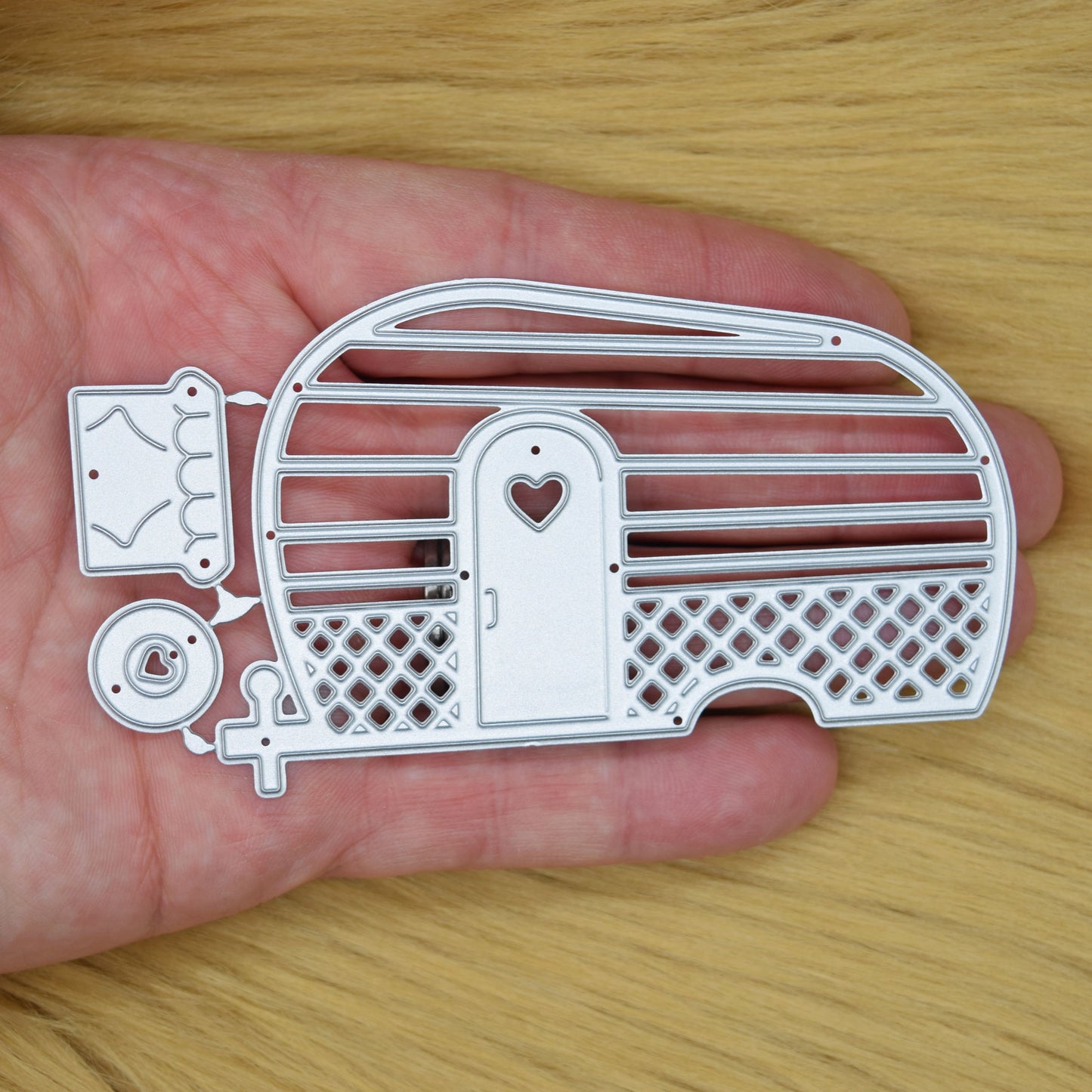 Retro caravan metal cutting die shown in hand to demonstrate the finished die size