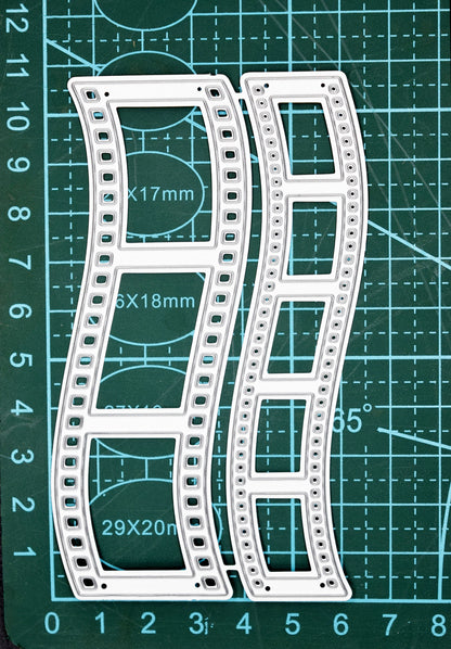 Retro film strip metal cutting dies displayed on a cutting mat for size reference