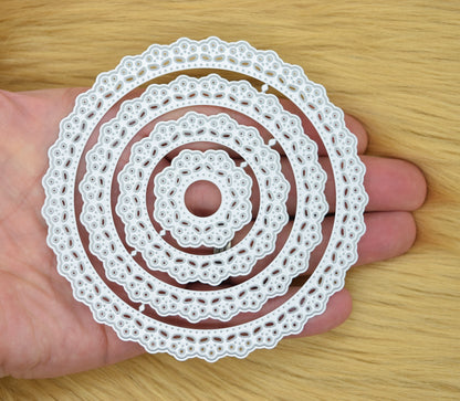Set of round lace patterned nesting metal cutting dies held in hand showing size