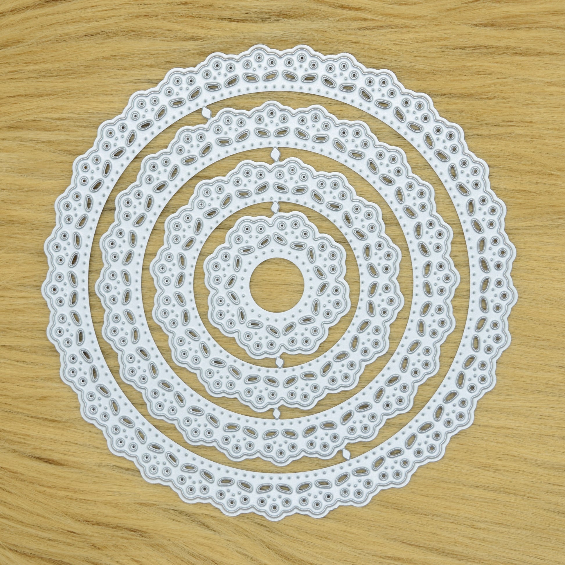 Round lace patterned nesting metal cutting dies on faux fur surface