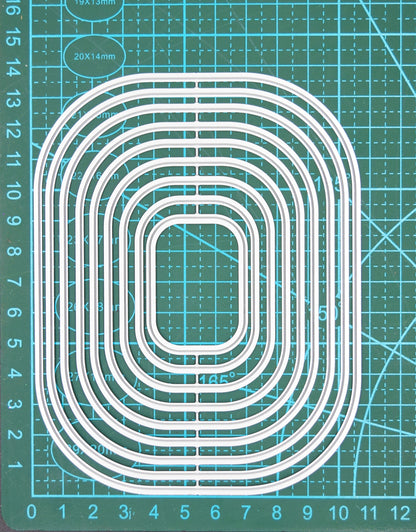 Rounded corner rectangle nesting metal cutting dies set on measuring mat showing size scale