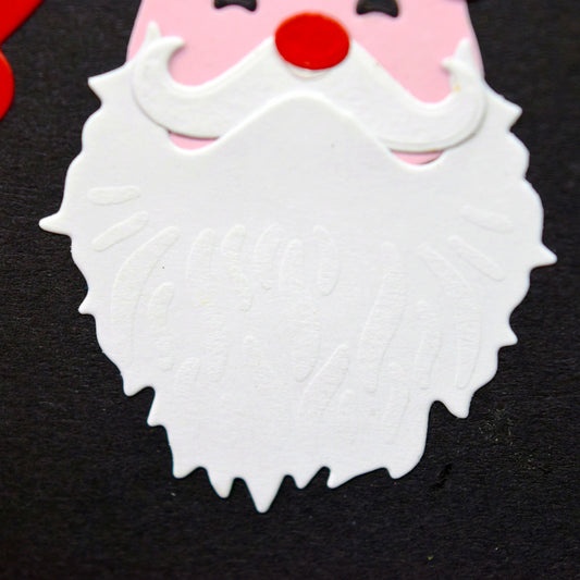 Close-up of the layered Santa topper showing embossed beard detail and a curled moustache, made with metal cutting dies for Christmas papercraft.