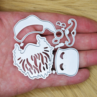 Santa face metal cutting dies held in a hand to show the size of the joined set for Christmas card making.