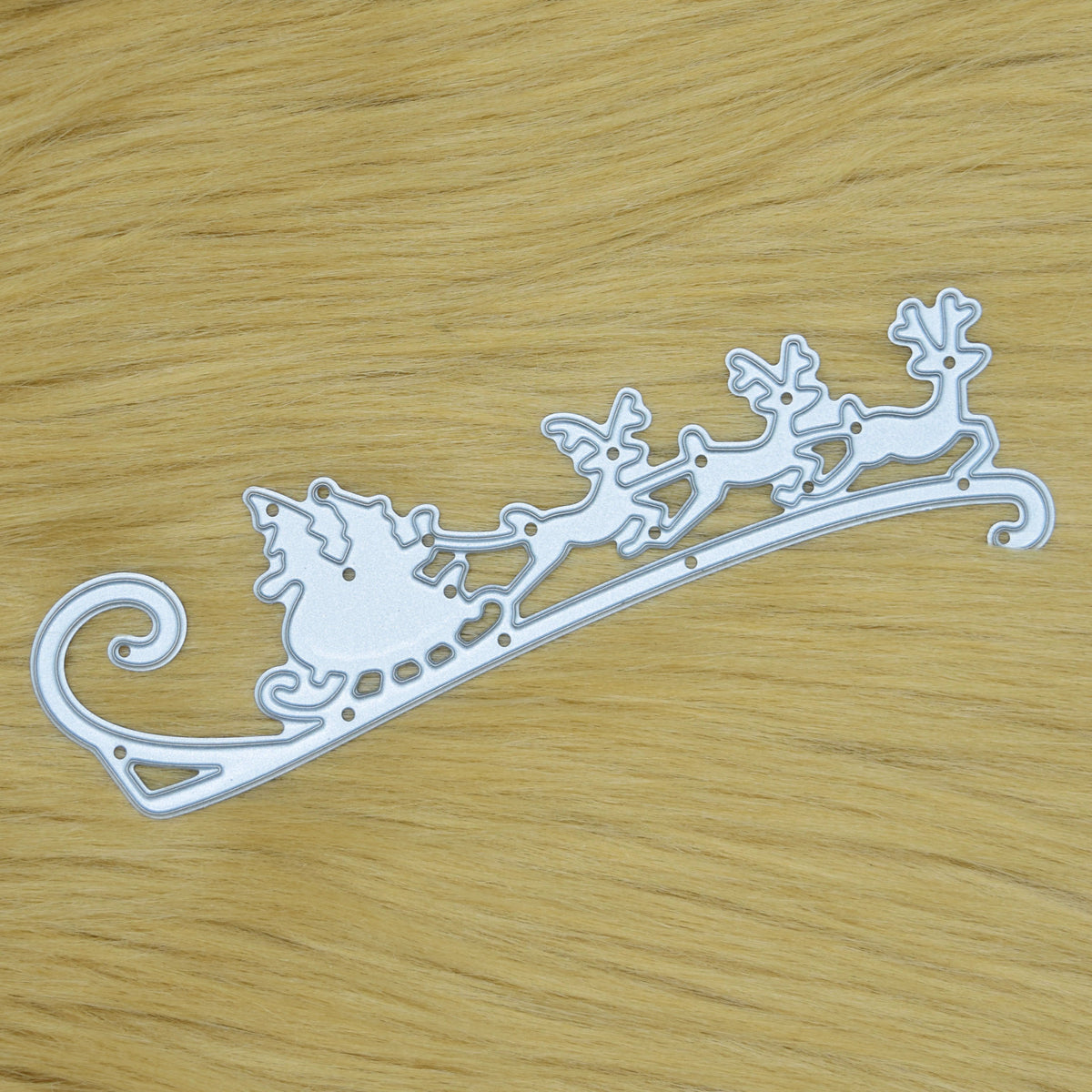Santa sleigh and reindeer metal cutting die photographed on faux fur background