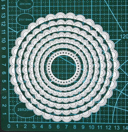 Scalloped circle nesting metal cutting dies shown on cutting mat for size reference