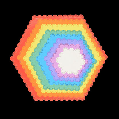 Colourful graduated scalloped hexagon shapes cut from card using nesting metal cutting dies for layering and matting.