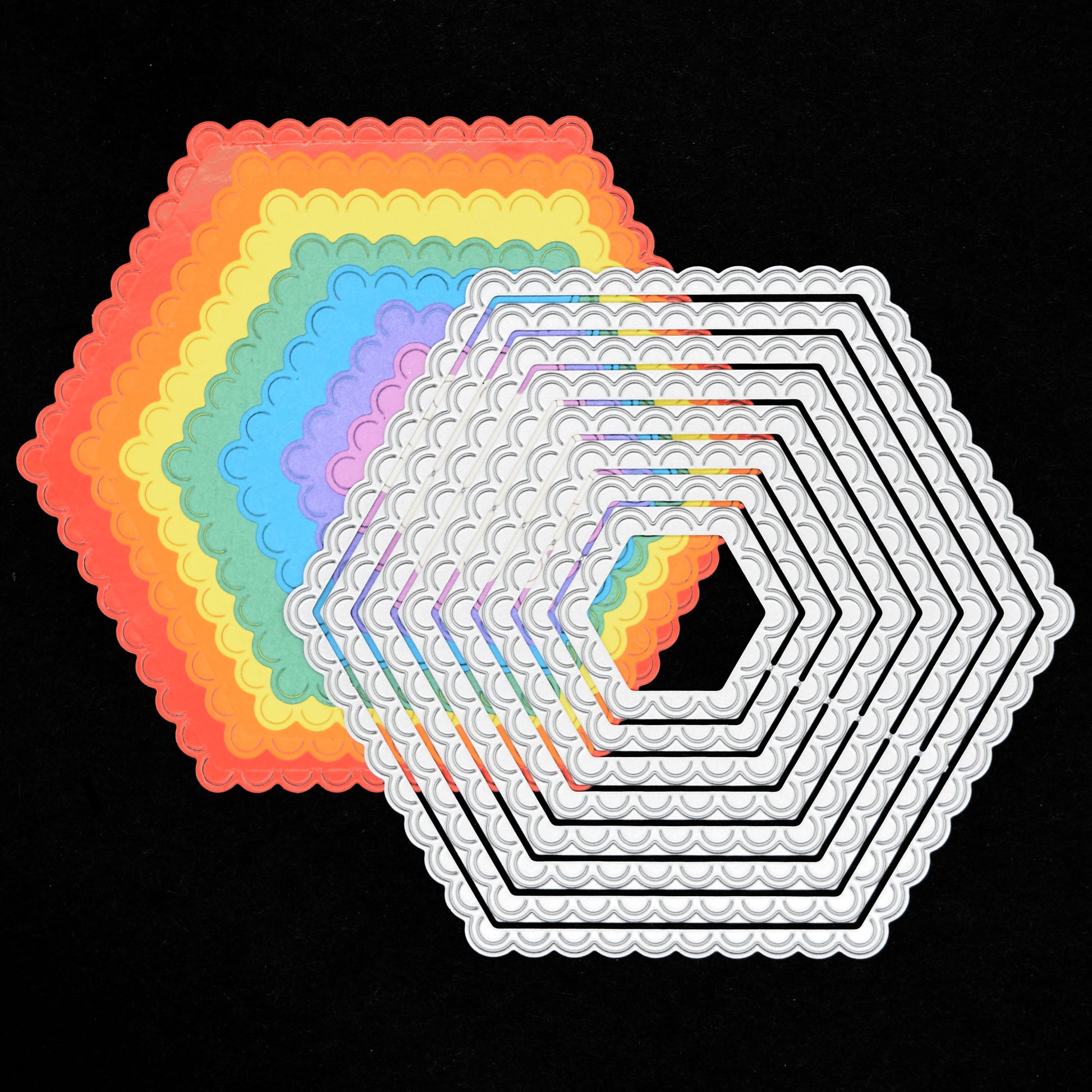 Graduated scalloped hexagon nesting metal cutting dies layered over colourful card shapes to demonstrate the different sizes.