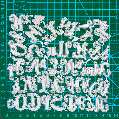 Uppercase and lowercase script alphabet metal cutting dies displayed on a centimetre cutting mat for size reference