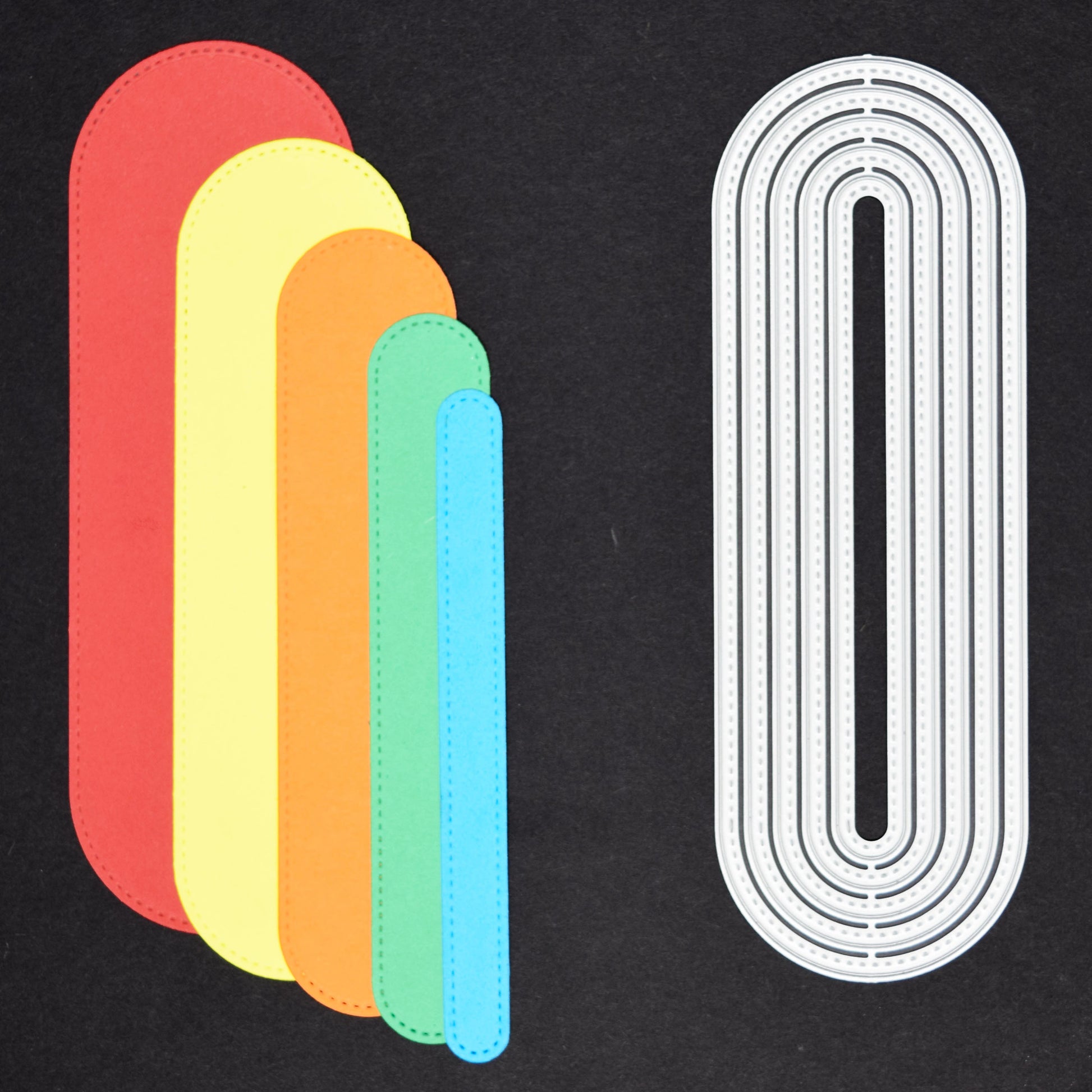 Slimline oval die cut shapes in coloured cardstock alongside matching metal cutting dies