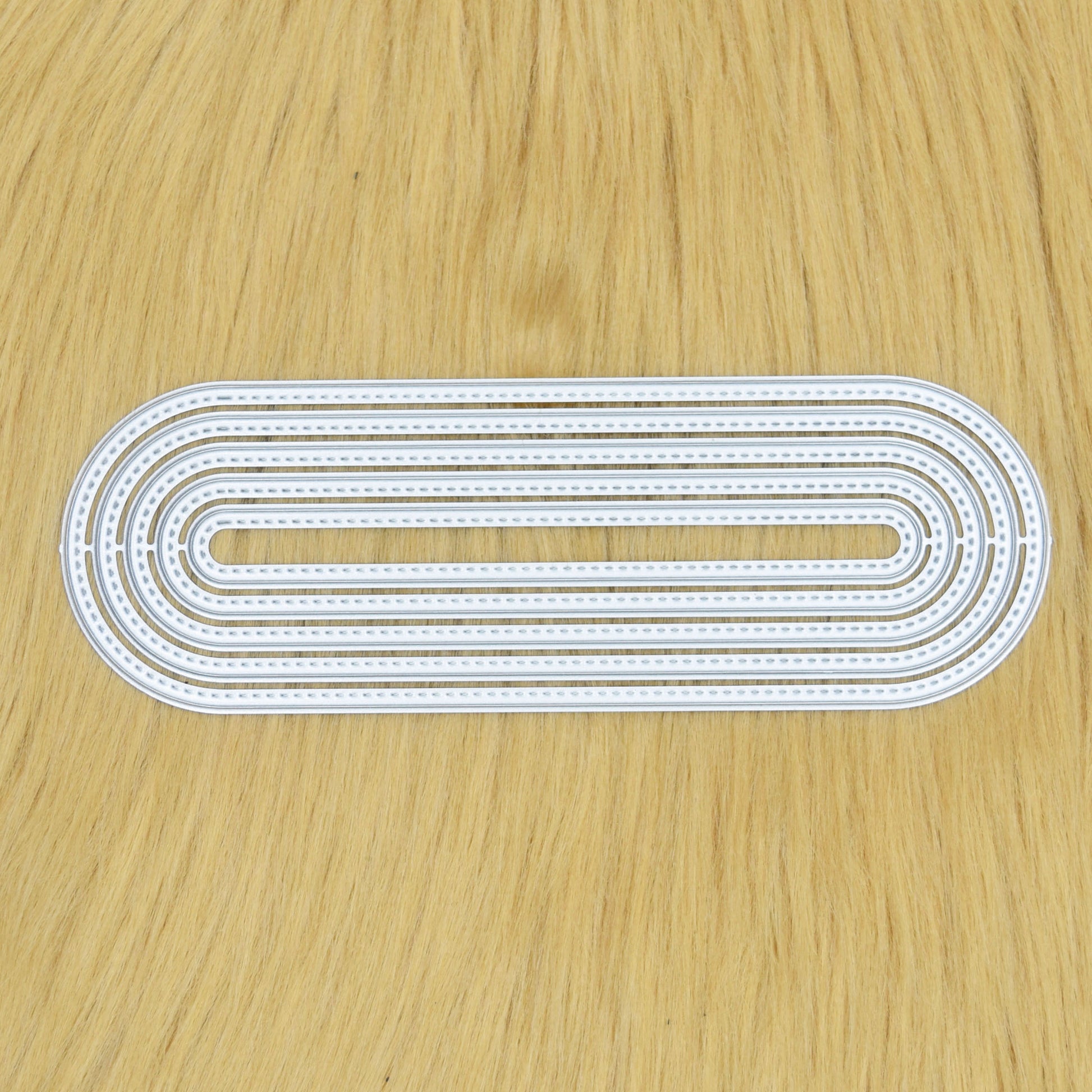 Stitched slimline oval metal cutting dies set arranged together showing elongated nesting shapes