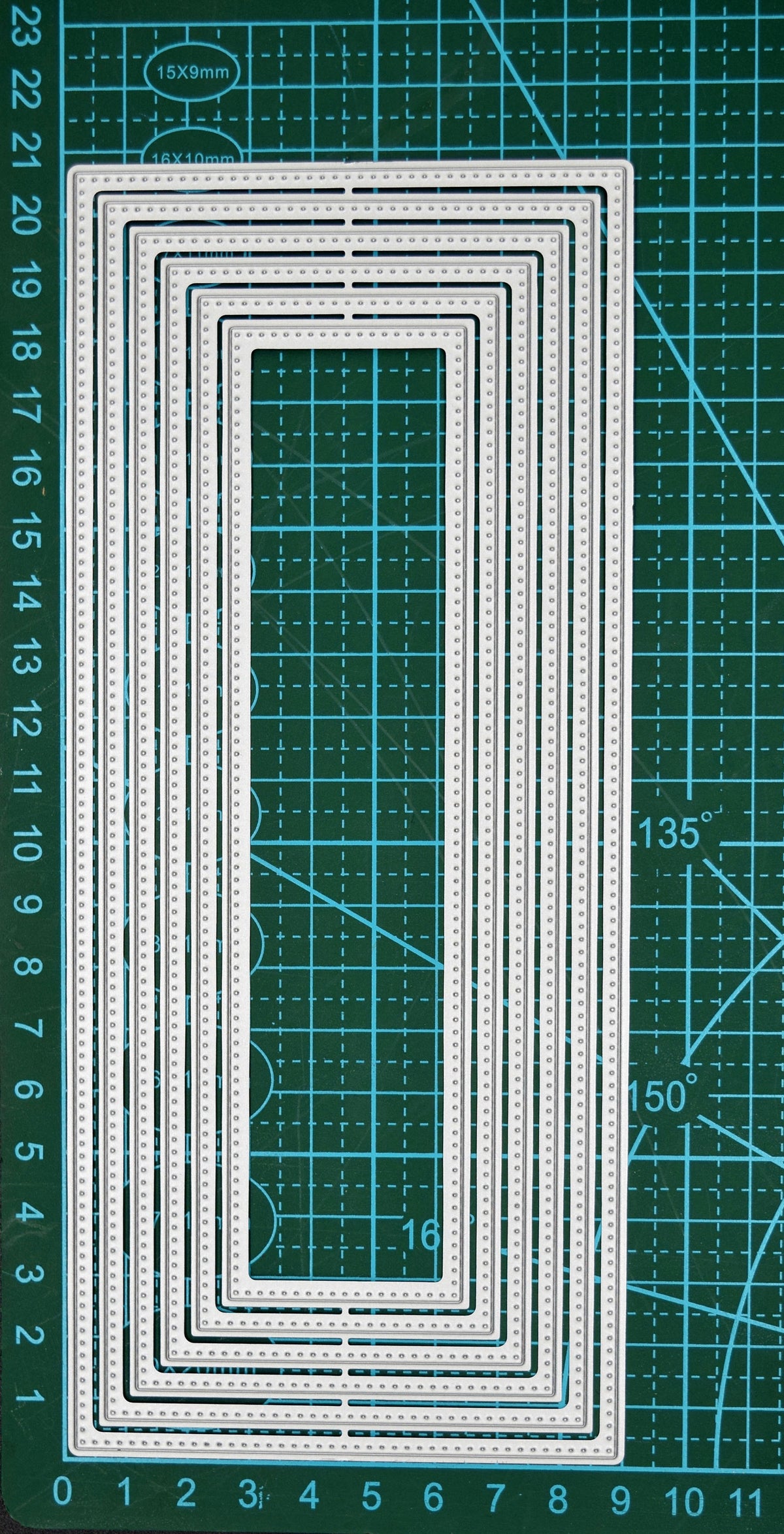 Large slimline rectangle nesting metal cutting die set displayed on a cutting mat to show the graduated sizes and dotted edge detail.