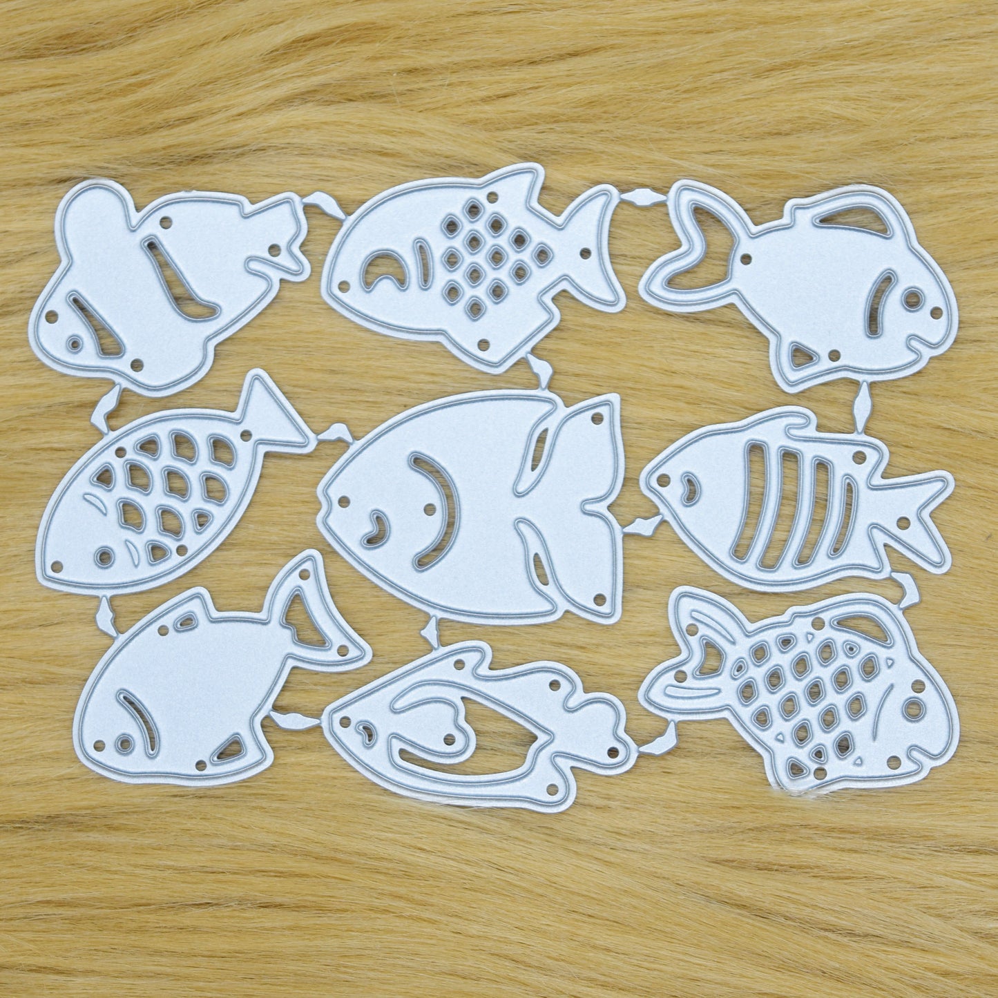 Small fish metal cutting dies set on wooden background