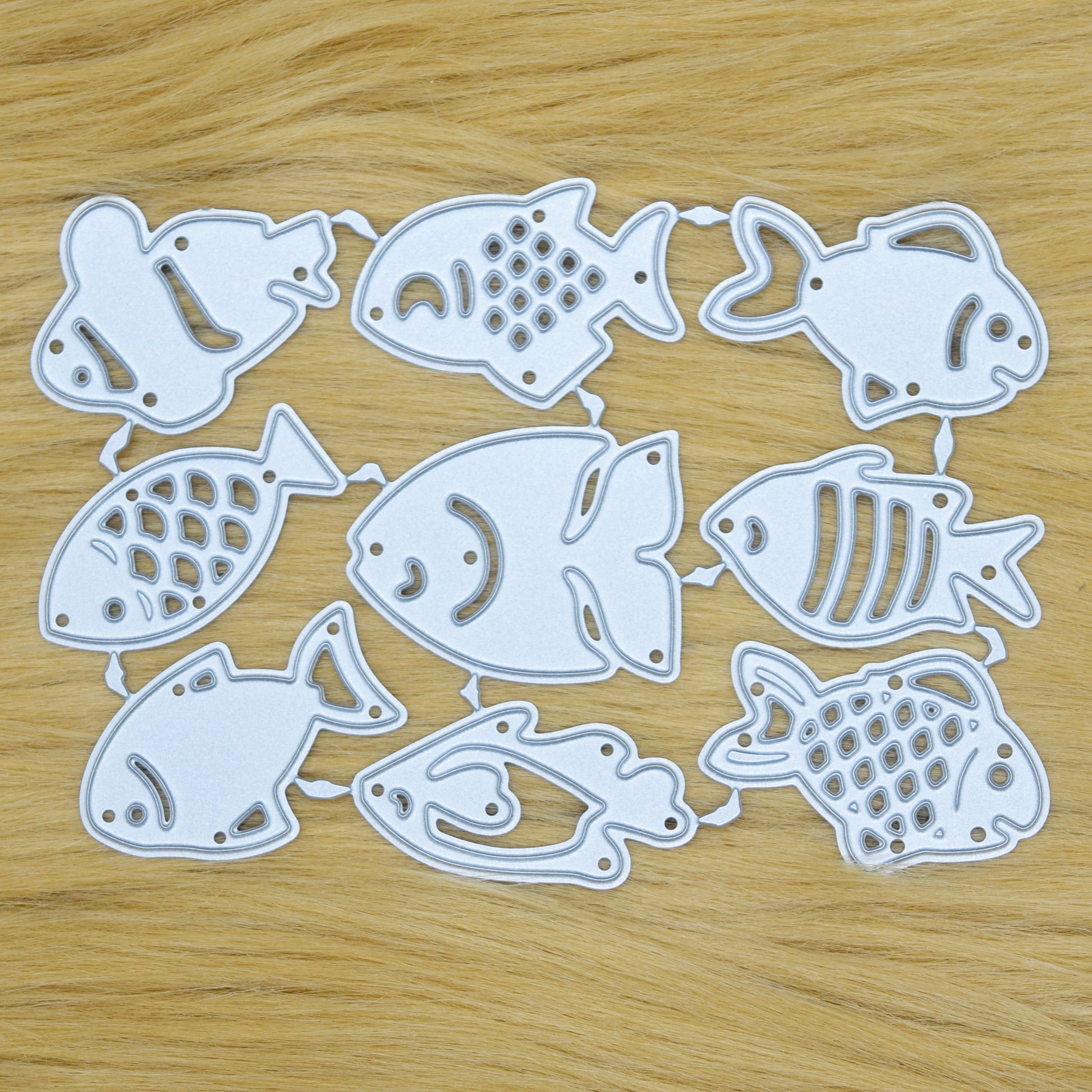 Small fish metal cutting dies set on wooden background