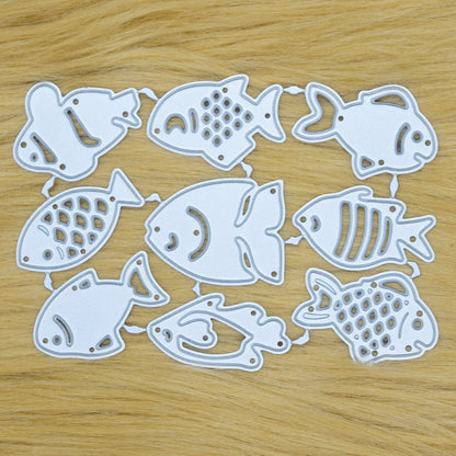 Small fish metal cutting dies set on wooden background