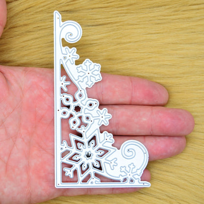 Christmas snowflake corner border metal cutting die held in hand to show its large size and detailed design.