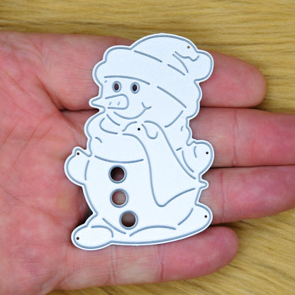 Snowman metal cutting die held in a hand to show its size for Christmas card making.