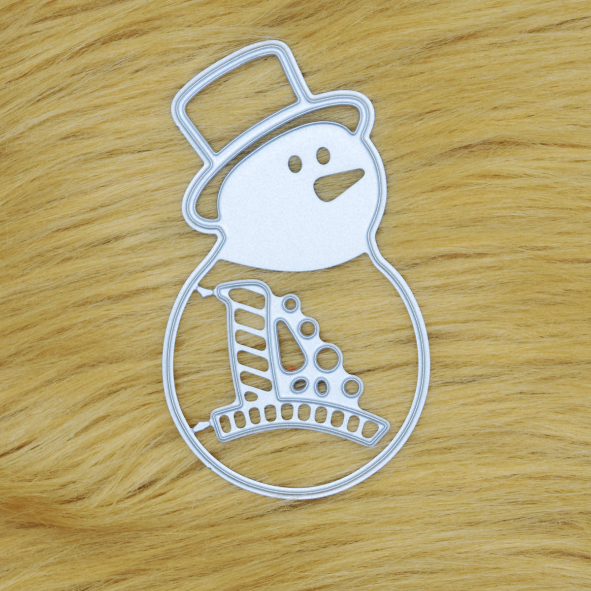 Snowman metal cutting die set on a tan faux fur background, showing the joined pieces for Christmas papercraft.