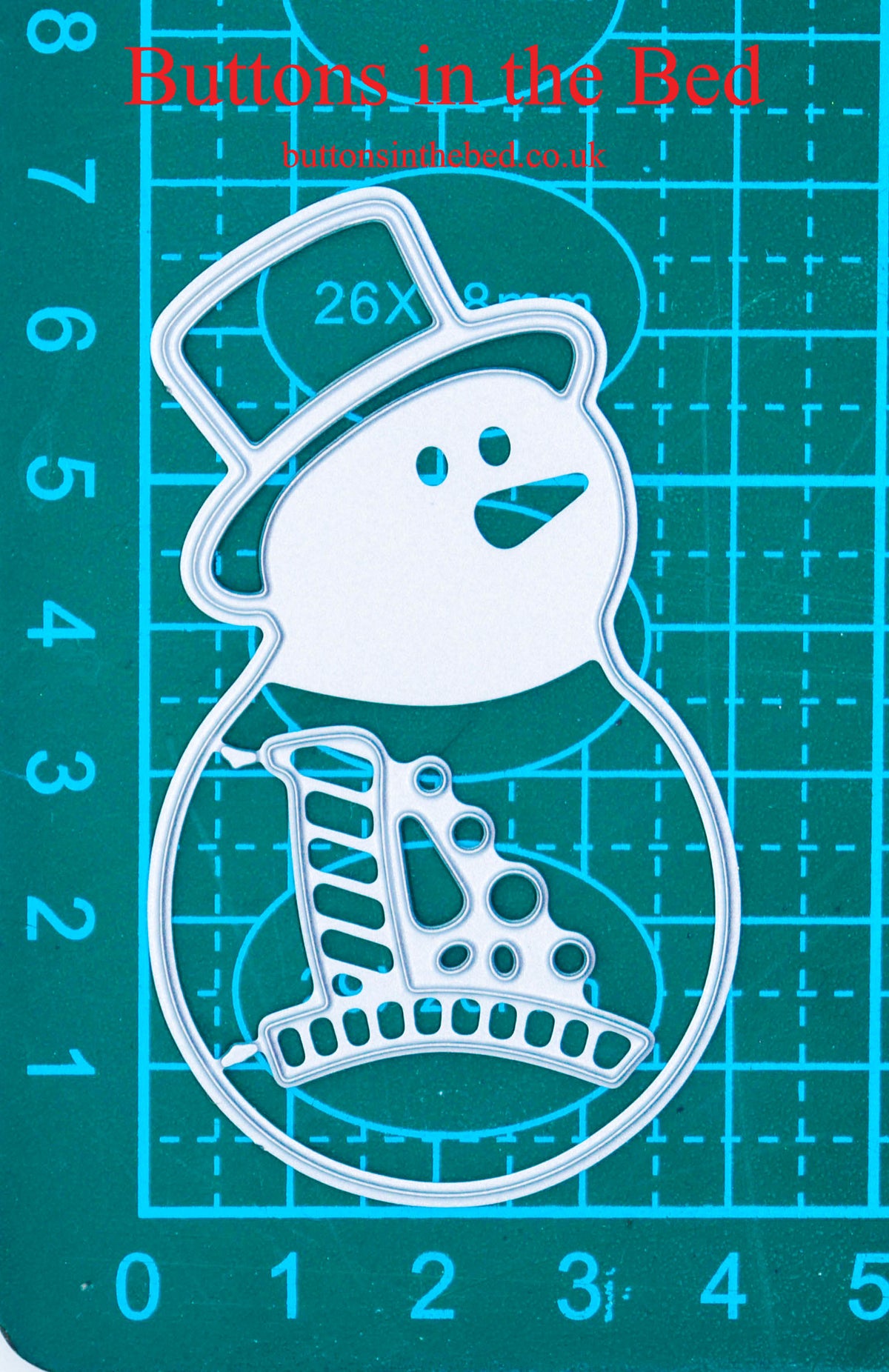 Snowman metal cutting die set on a centimetre cutting mat, showing its overall size, with Buttons In The Bed branding.