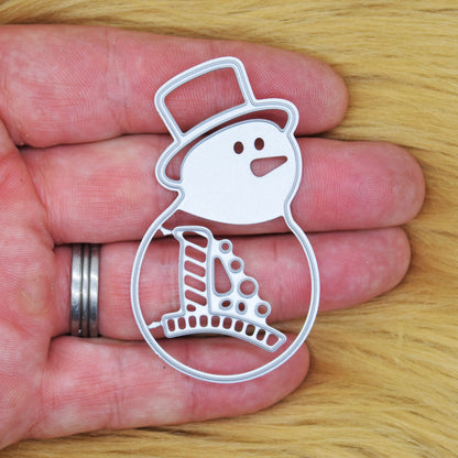 Snowman metal cutting die set held in a hand to show its size for festive papercraft.