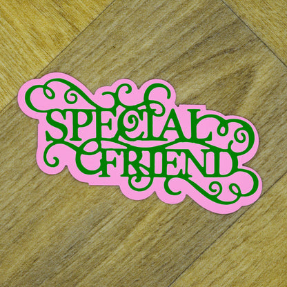 Pink and green layered Special Friend sentiment cut showing the decorative wording and coordinating background shape.