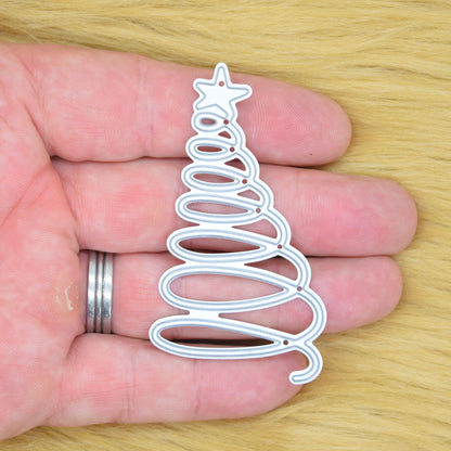 Spiral Christmas tree metal cutting die held in hand to show the overall size of the modern festive design.