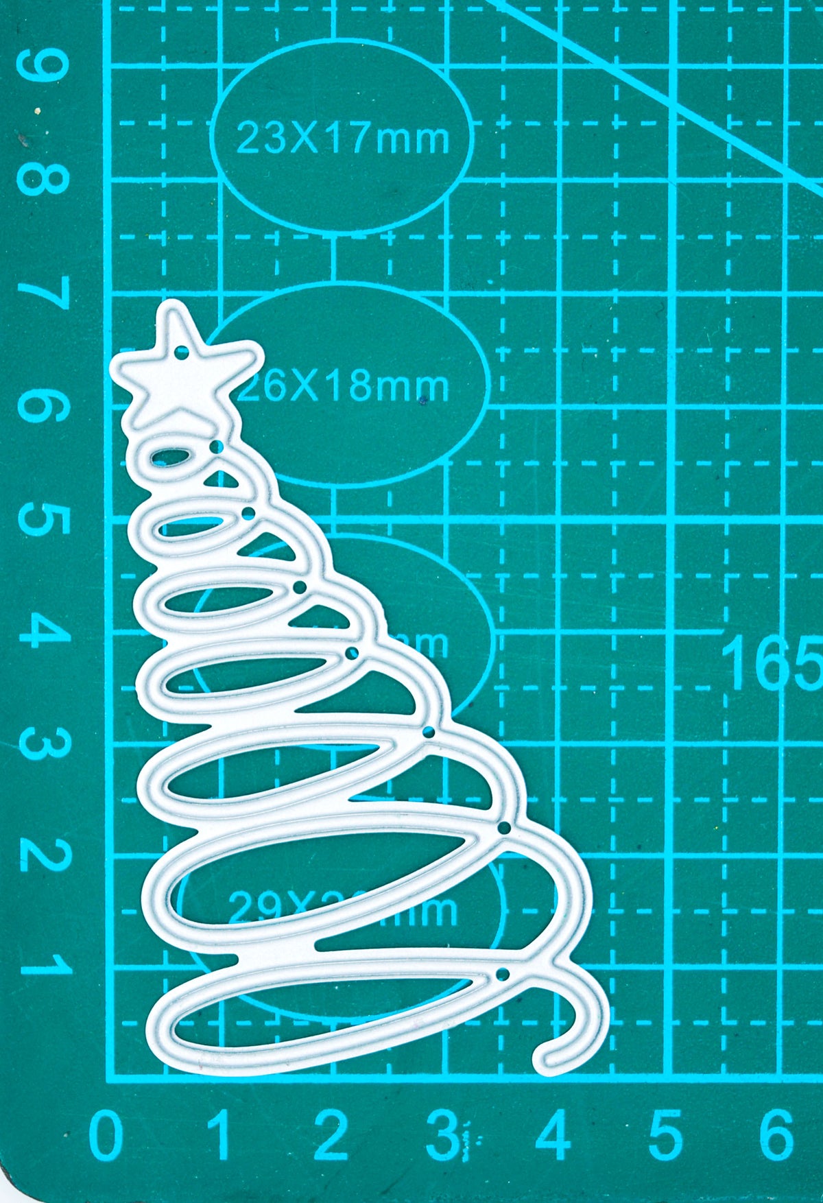 Spiral Christmas tree metal cutting die shown on a centimetre cutting mat for size reference.