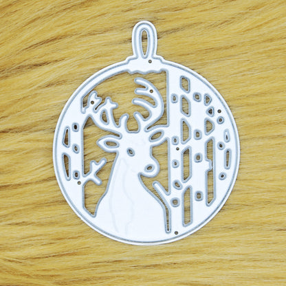Stag Christmas bauble metal cutting die on a tan faux fur background, showing the deer, trees and hanging loop for papercraft.
