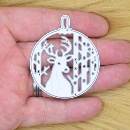 Stag Christmas bauble metal cutting die held in a hand to show its size for festive card making.