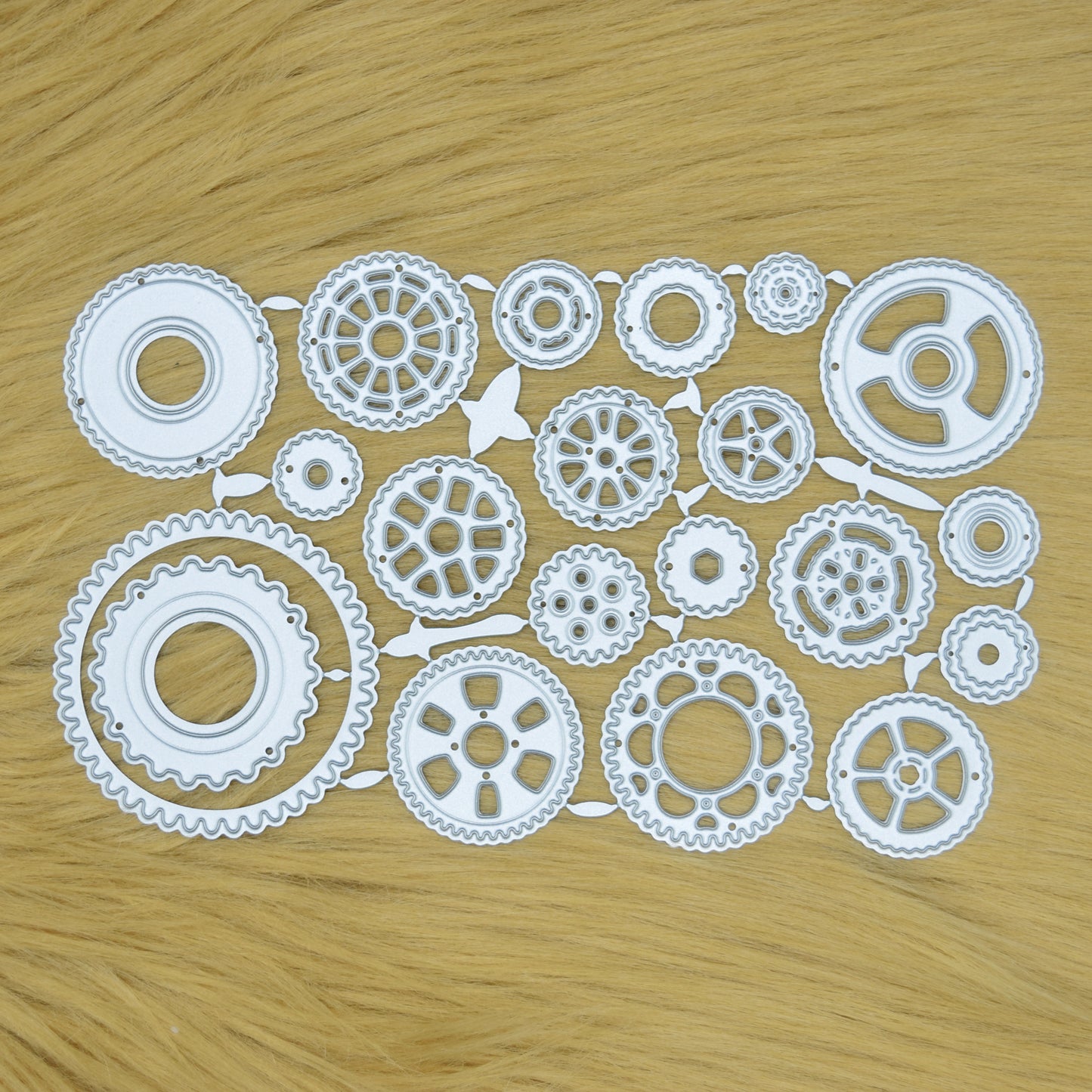 Steampunk gear wheel metal cutting dies set displayed on a faux fur background