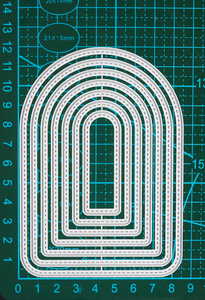 Seven graduated stitched arch metal cutting dies shown on a centimetre cutting mat for clear size comparison.