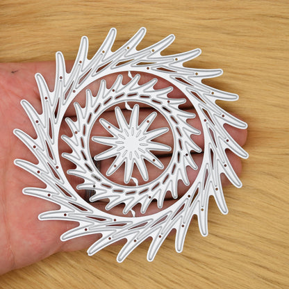Decorative circular swirl dies shown in hand for scale