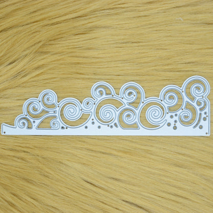 Decorative swirly waves metal cutting die held in hand to show its size and detailed spiral design