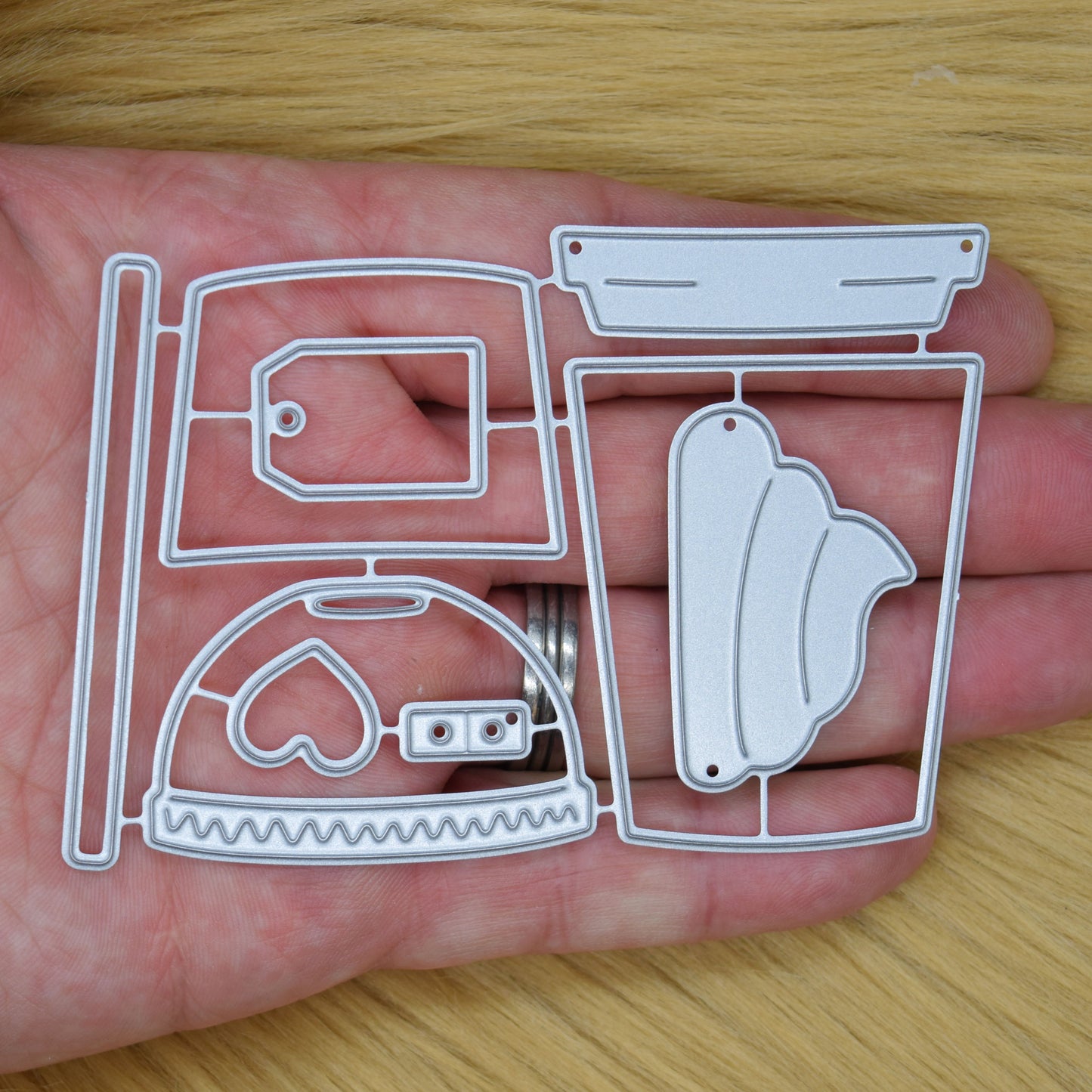 Takeaway coffee, latte and boba tea metal cutting dies set held in hand to show the size of the drink cup die pieces