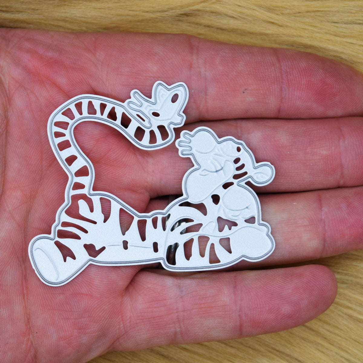Tigger metal cutting die held in a hand to show its size for character card making.