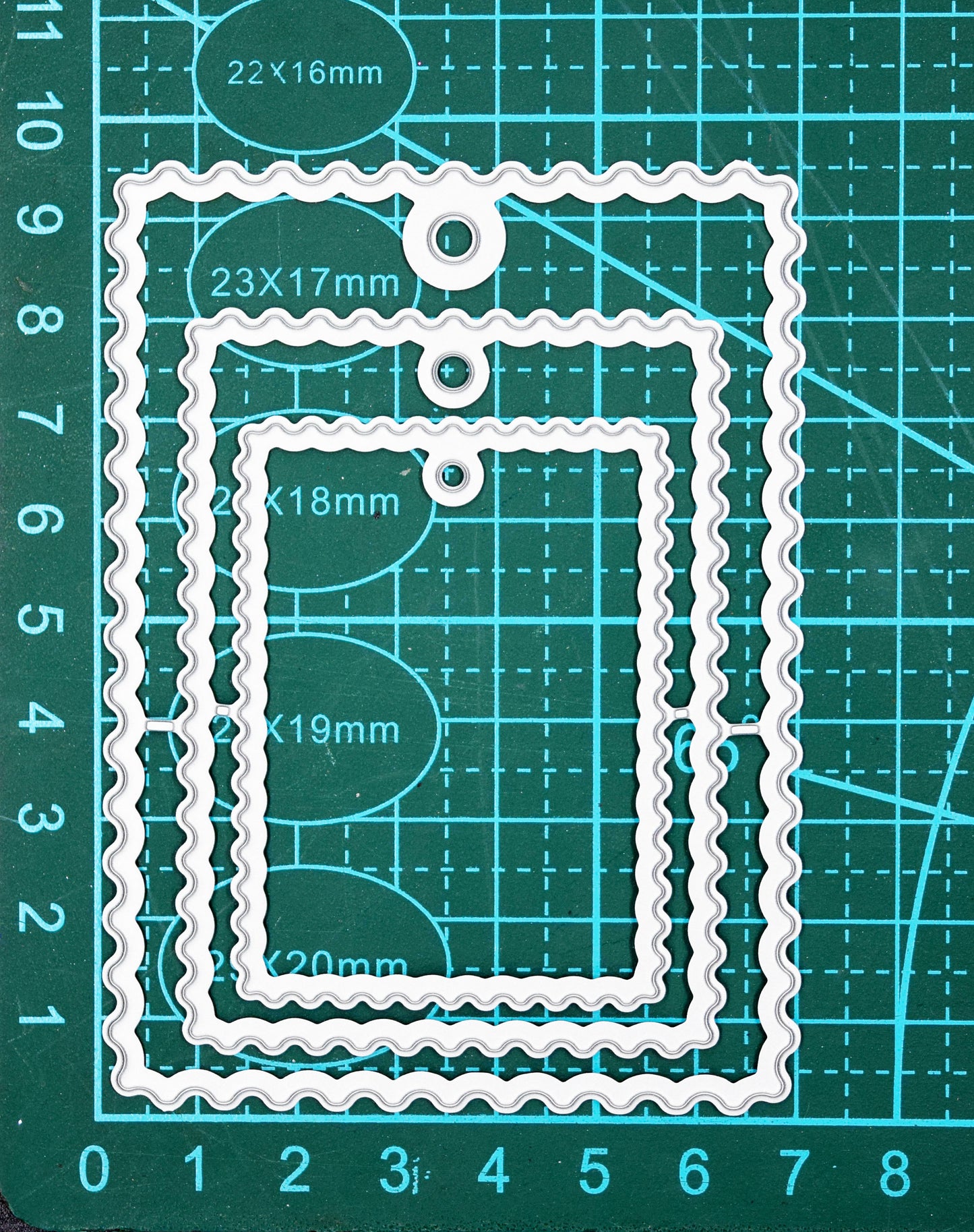 Wavy tag nesting dies on cutting mat showing size reference