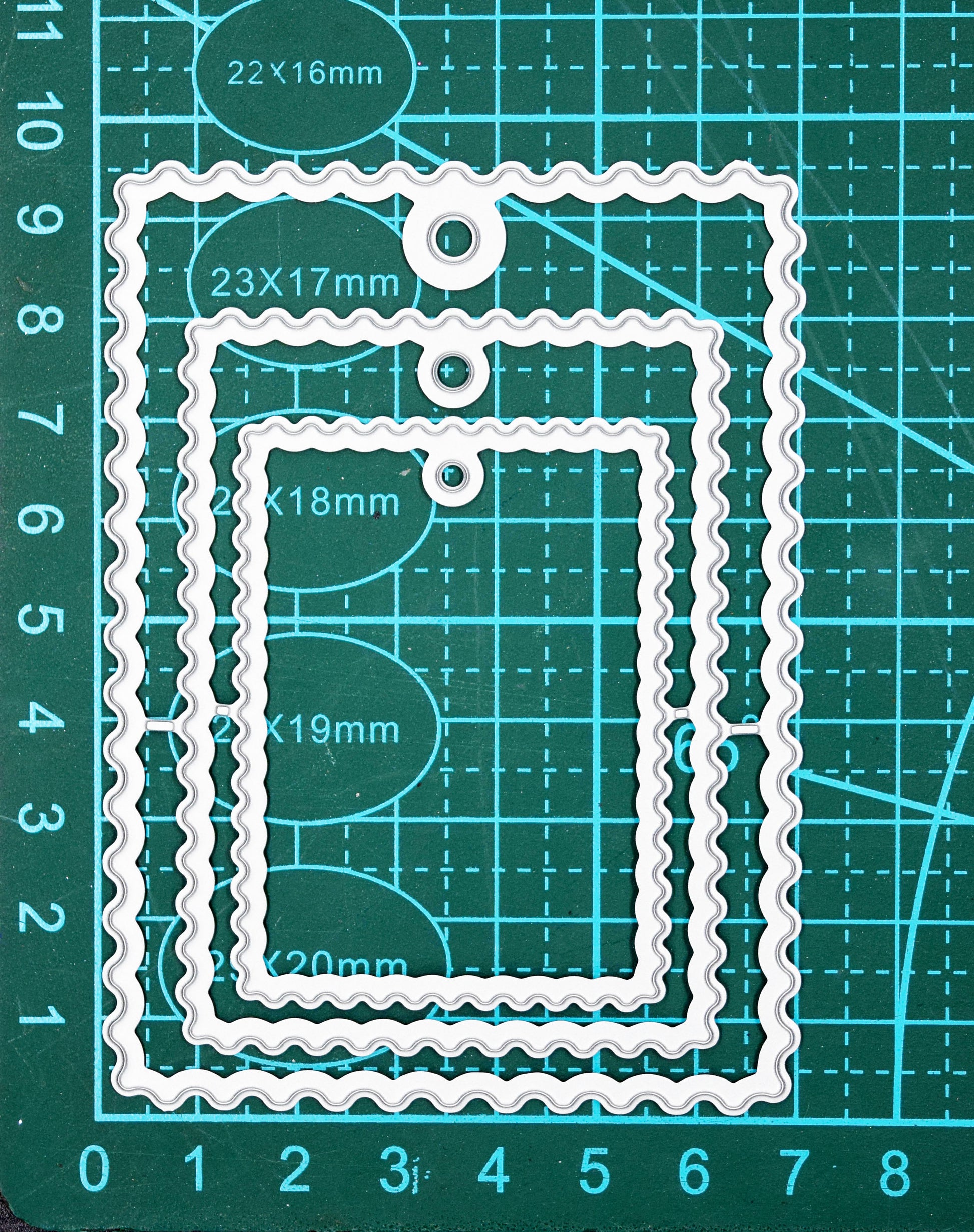 Wavy tag nesting dies on cutting mat showing size reference