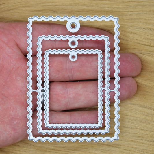 Wavy tag nesting metal cutting dies shown in hand for scale