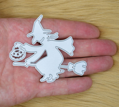 Witch on broomstick metal cutting die shown in hand for size reference