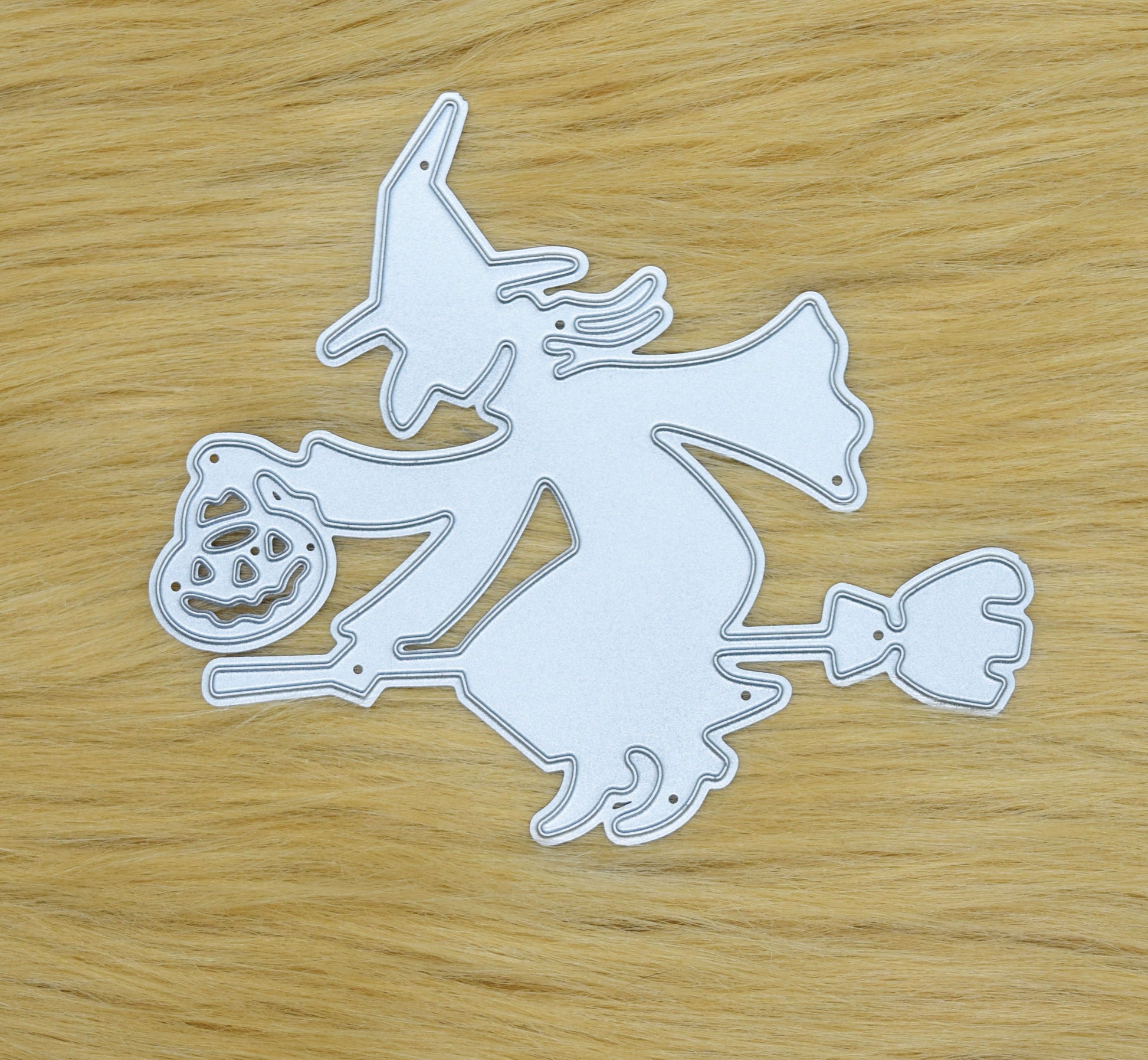 Witch on broomstick metal cutting die on faux fur background